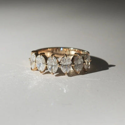 Gold ring with diamonds on a light gray background