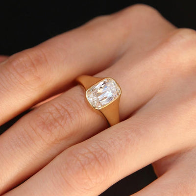 Gold ring with a diamond on a hand against a black background